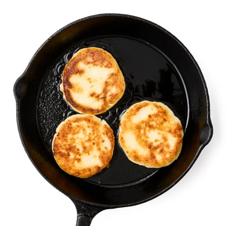 03a Felicity Cloake’s arepas cooking in a pan. Put a lightly greased, heavy frying pan on a medium heat and, once it’s hot, add as many arepas as will fit comfortably without them touching. Immediately turn down the heat to medium-low, cover (use a baking tray, board or foil if you don’t have a pan lid) and cook, shaking the pan occasionally to stop the arepas sticking, for about five or six minutes, until the base is golden brown. Turn over, repeat on the other side and serve spread with butter to serve.